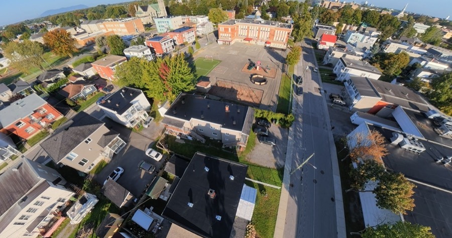 Vue en plongée de toits d'immeubles résidentiels près d'une cour d'école